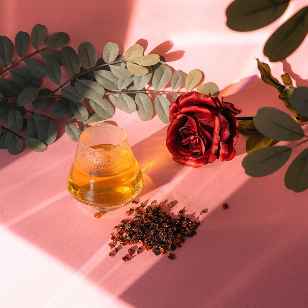 Positively Botanicals Organic Rosehips herbal supplement steeped into a warm infusion, displayed with rose petals for a soothing drink experience.