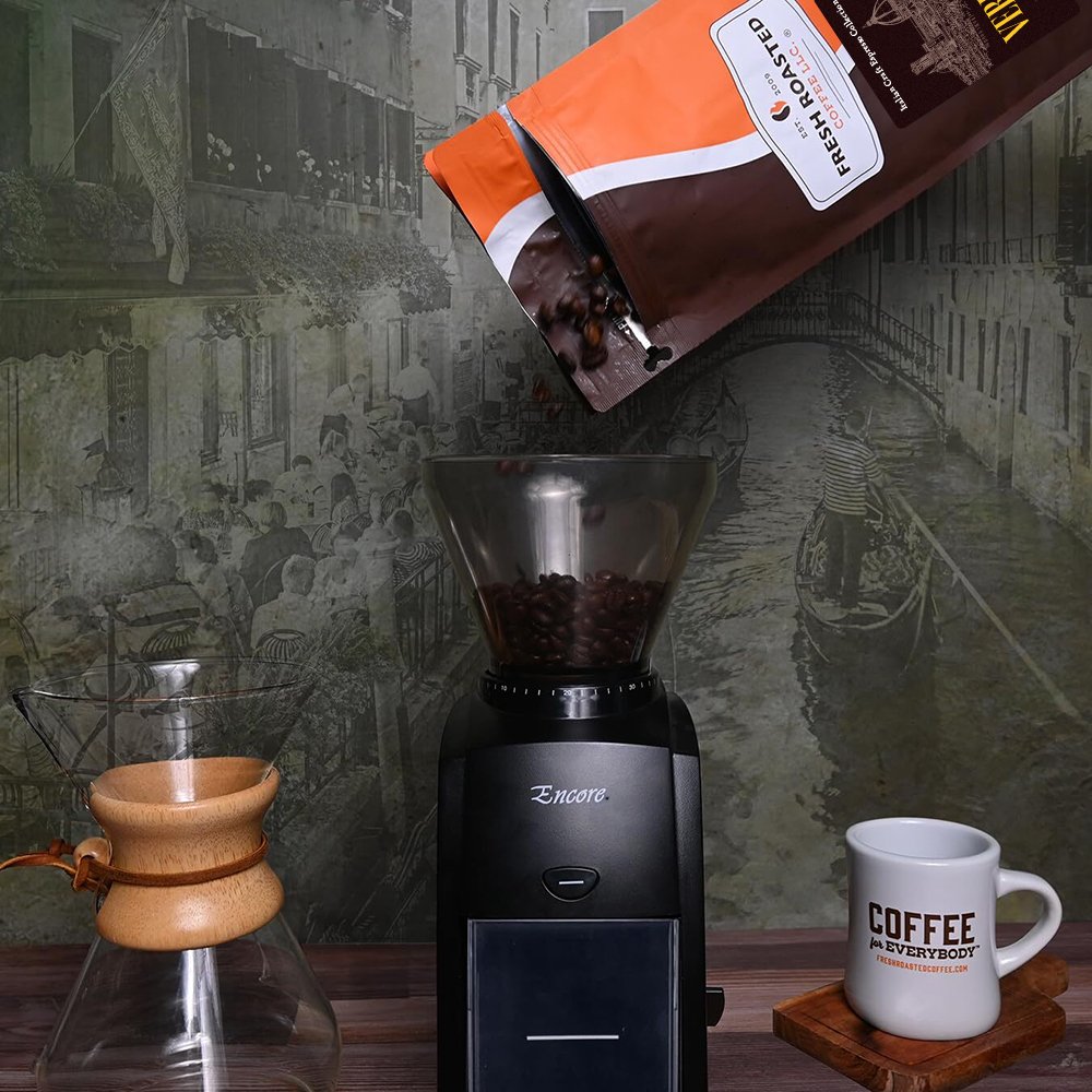 Verrocchio whole espresso beans from Fresh Roasted Coffee being poured into a grinder, ideal for brewing full-bodied espresso with fruit, chocolate, and nutty flavors.