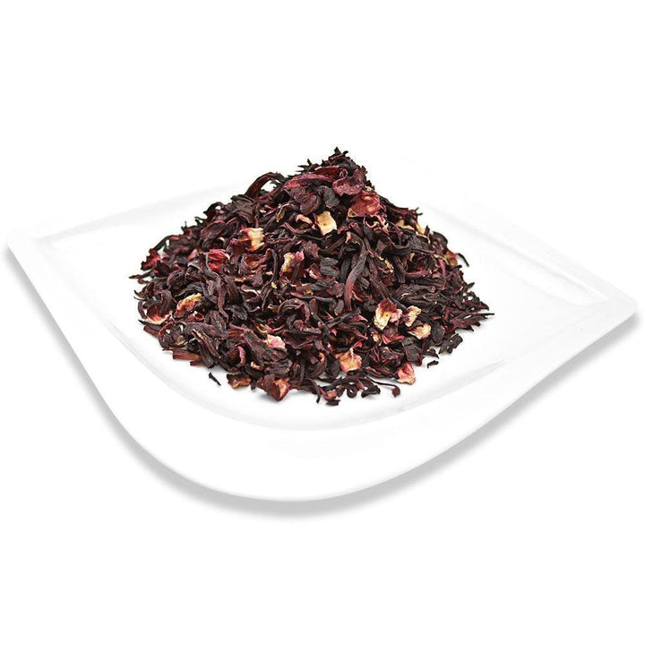Positively Tea Company Organic Hibiscus loose leaf petals displayed on a white plate, showcasing their rich color and tangy flavor profile.