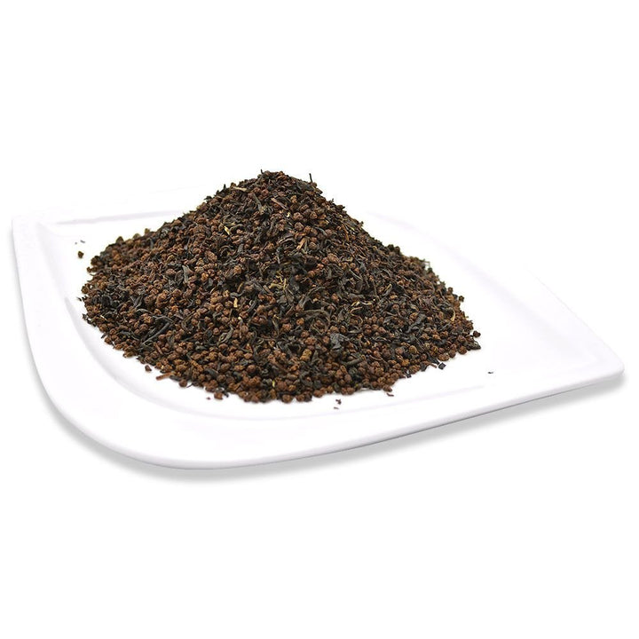 Loose Scottish Breakfast tea leaves served on a white plate, showcasing a strong and robust black tea blend.